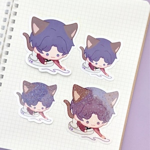 May include: Four stickers featuring a cartoon character with cat ears and purple hair. The character is wearing a maroon outfit and is posed as if drawing. The stickers are on a white grid paper notebook.