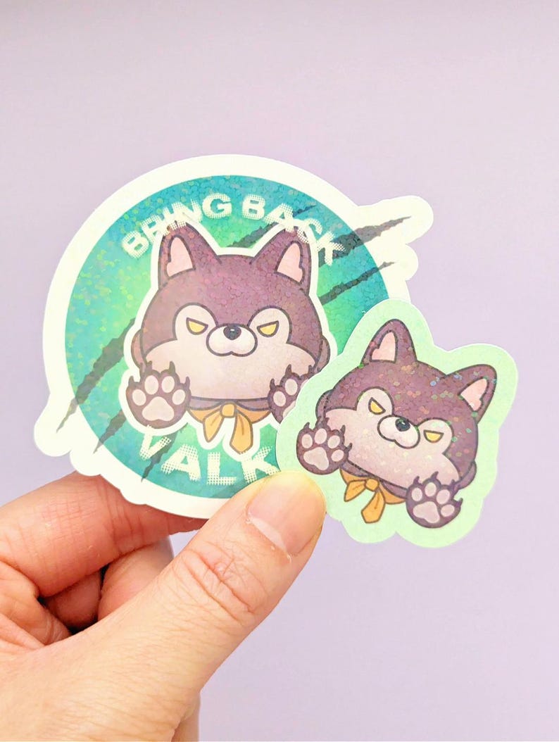 May include: Two circular stickers featuring a cartoon purple dog with yellow eyes and a yellow neck ribbon. The larger sticker has a teal holographic background with the text BRING BACK VALK and black claw marks. The smaller sticker is die-cut.