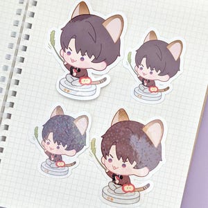 May include: Four stickers featuring a cartoon character with cat ears, holding a green sprig. The character is wearing a dark red jacket and sitting on a white and gray platform. The stickers are on a grid-lined notebook page.