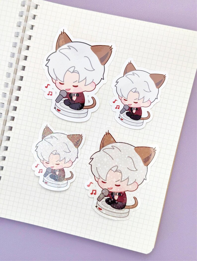 May include: Four stickers featuring a cartoon character with white hair, cat ears, and a red jacket, singing into a microphone. Each sticker has a musical note icon. The stickers are on a notebook page.