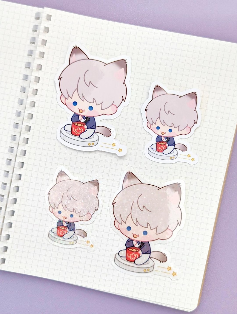 May include: Four stickers featuring a cartoon character with cat ears, light gray hair, and blue eyes. The character is wearing a dark blue suit and holding a red container. The stickers are on a white notebook page with a grid pattern.