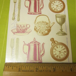 May include: A sheet of vintage-style stickers featuring images of teapots, forks, spoons, a pocket watch, and a teacup. The stickers are printed on white paper with a light brown background. The text "Gifted Stickers" is printed at the top of the sheet.