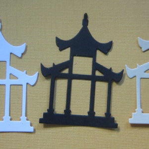 May include: Three paper cutouts of a traditional Chinese pagoda, one white, one black, and one white. The cutouts are approximately 2 inches tall and are arranged in a row.