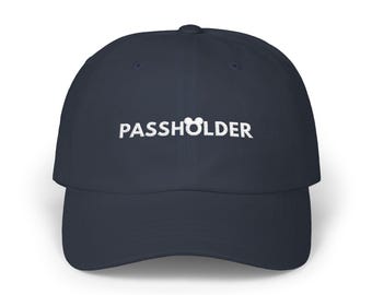 Könnte beinhalten: Marineblaue Baseballkappe mit dem weißen Schriftzug "PASSHOLDER". Der Buchstabe "O" in "PASS" ist durch eine Mickey Mouse Kopf Silhouette ersetzt. Eine lässige Kappe.