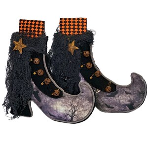 May include: Pair of Halloween witch boots with a purple and gray patterned design. The boots have black accents, decorative stars, and small bells. The tops are orange and black checkered.