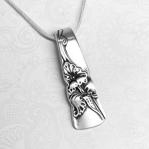 May include: A silver necklace with a pendant made from a vintage spoon. The spoon has been transformed into a delicate floral design.