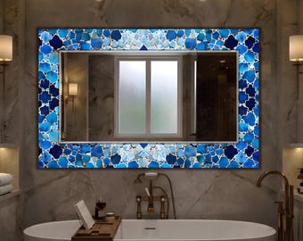 May include: A rectangular wall mirror featuring a wide, decorative frame composed of various shades of blue, including navy, azure, and light blue, arranged in a geometric mosaic pattern with white grout lines surrounding a clear glass centre.