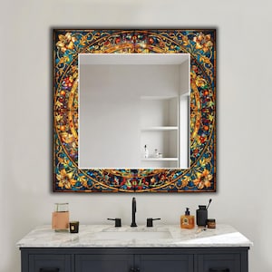 May include: Square mirror with a stained glass design. The frame has a floral and fruit pattern in blue, gold, orange, and red. The mirror is above a bathroom vanity with a marble countertop.