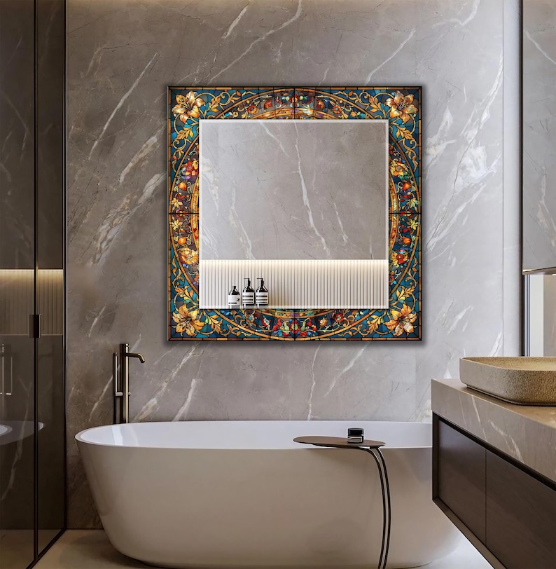 K&ouml;nnte beinhalten: Quadratischer Spiegel mit einem Rahmen im Glasmalerei-Stil mit floralen und fruchtigen Designs in Gelb, Blau und Rot. Der Spiegel ist &uuml;ber einem wei&szlig;en Regal mit drei Flaschen in einem modernen Badezimmer angebracht.