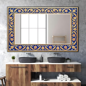 Könnte beinhalten: Rechteckiger Spiegel mit einem Rahmen mit lebendigem blauem und goldenem Blumendesign. Der Rahmen weist komplizierte Muster mit orangefarbenen und gelben Blumenmotiven auf. Der Spiegel ist über einem Holzwaschtisch mit schwarzen Waschbecken montiert.