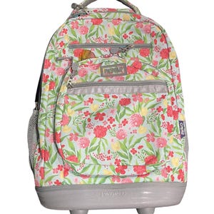 May include: A rolling backpack featuring a light blue base with a floral pattern of red and yellow flowers and green leaves. It includes multiple zippered compartments, a top handle, side mesh pockets, and a gray base with wheels and JWORLD branding.