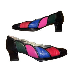 May include: A white ceramic mug with a black handle and the text "But First, Coffee" in a black, bold font. The mug is sitting on a white surface. The mug is approximately 4 inches tall.