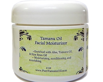 May include: A white jar with a green and brown label that reads "Tamanu Oil Facial Moisturizer". The label also says "Enriched with Aloe, Tamanu Oil, & Rice Bran Oil" and "Moisturizing, conditioning, and nourishing". The jar is 2 ounces and the website is www.PureTamanuOil.com.