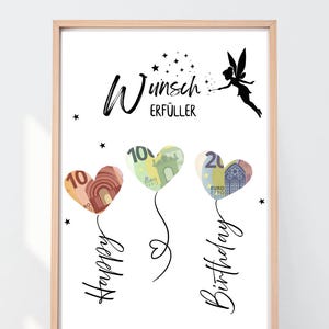 May include: A framed print with the words "Wunsch Erfüller" and "Happy Birthday" in black script. Three heart-shaped balloons, each with a Euro bill design, float below. A fairy silhouette and stars complete the design.