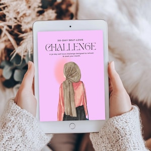 May include: A tablet displays a pink graphic with the text "30-DAY SELF-LOVE CHALLENGE." The image features an illustration of a person wearing a hijab, a pink shirt, and a black skirt. The text below says, "A 30-day self-love challenge designed to refresh & reset your month."