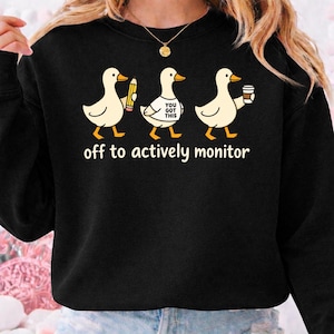 May include: A set of three ceramic mugs with a speckled, matte finish. The mugs are in shades of cream, light gray, and dark gray. Each mug has a simple, minimalist design and a rounded handle.