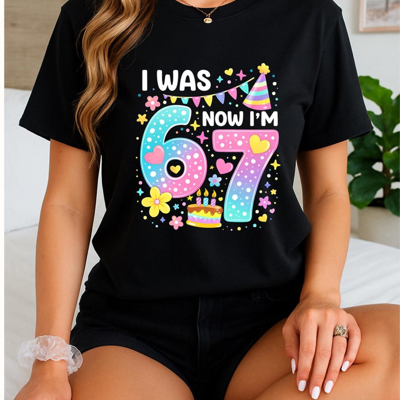 Może przedstawiać: Czarny t-shirt z napisem "I WAS 6, NOW I'M 7" w kolorowej, zabawnej czcionce. Projekt zawiera duże cyfry 6 i 7, serca, kwiaty, tort urodzinowy i czapeczkę urodzinową, idealny na urodziny.