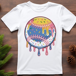 Puede incluir: Camiseta blanca con un gr&aacute;fico de b&eacute;isbol. La pelota de b&eacute;isbol es azul con costuras rosas, cubierta con glaseado amarillo y chispas de colores, con goteo rosa y azul. La camiseta est&aacute; hecha de un material suave. Dise&ntilde;o divertido.