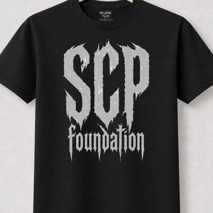 T-shirt de la Fondation SCP pour les amateurs de cadeaux un peu étranges, teintés d'occultisme, et de fêtes médiévales, cadeau idéal pour les joueurs de GN et les passionnés d'équipement paranormal.