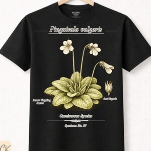 Könnte beinhalten: Schwarzes T-Shirt mit einer botanischen Illustration von Pinguicula vulgaris, einer fleischfressenden Pflanze, mit detaillierten Zeichnungen ihrer Blätter und Blüten. Das T-Shirt enthält auch den Text "Carnivorous Species" und "Specimen No. 27".