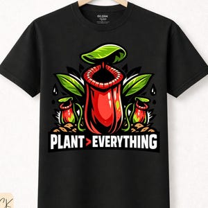 Könnte beinhalten: Schwarzes T-Shirt mit einem farbenfrohen Grafikdesign einer Kannenpflanze und dem Text "PLANT > EVERYTHING". Das Design umfasst rote, grüne und schwarze Elemente, mit einem Blatt und Wassertropfen. Das T-Shirt ist aus Premium-Baumwolle.
