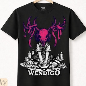 Puede incluir: Camiseta negra con un gráfico de una figura con una máscara de calavera y cuernos, rodeada de velas y un pentagrama. La palabra "WENDIGO" está impresa en blanco. La camiseta también tiene las palabras "BLACK premium cotton".