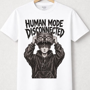 May include: A white short-sleeve t-shirt featuring a black graphic print of a person in a hoodie lifting a wolf mask above their head. The text "HUMAN MODE DISCONNECTED" is printed in a jagged, distressed font above the illustration.