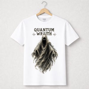 以下が含まれることがあります： 「QUANTUM WRAITH」の文字と、光る目と鉤爪の手を持つフード付きの人物のイラストが描かれた白いTシャツ。 グラフィックはグレーと黒の色合いです。