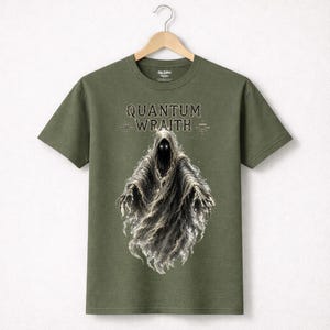 以下が含まれることがあります： オリーブグリーンのTシャツ。光る目を持つ幽霊のような姿と、ゴシック体の「QUANTUM WRAITH」の文字が描かれています。フードをかぶった幽霊が、煙のように流れる姿でデザインされています。