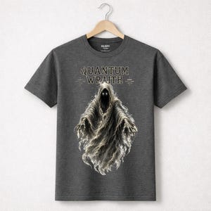以下が含まれることがあります： 暗い灰色のTシャツ。 幽霊のような姿が描かれており、光る目とフード付きのマントが特徴です。「QUANTUM WRAITH」の文字がその上に印刷されています。 Tシャツは木製のハンガーに掛けられています。