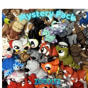 May include: A collection of small, articulated animal figurines in various colors including blue, orange, green, brown, and white. The figures feature large eyes and segmented bodies. The text Mystery Pack and Zoodlez are printed on the image.
