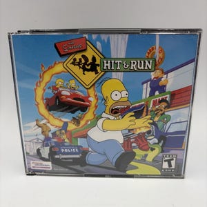 May include: The Simpsons Hit & Run video game in a clear plastic jewel case. The cover art features Homer Simpson running, a red car jumping through a ring of fire, a Springfield police car, and other characters against a blue sky background.