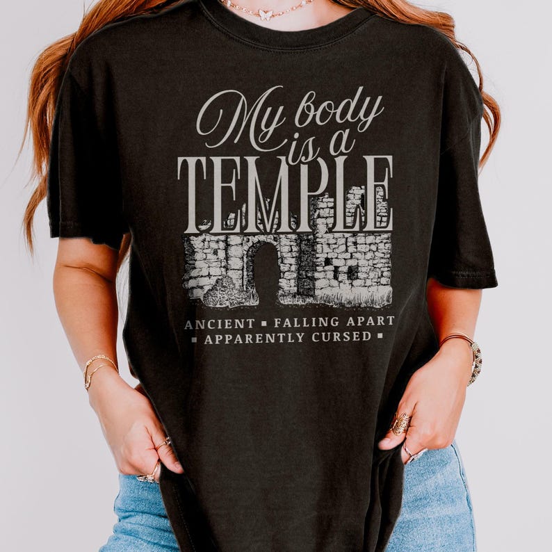 May include: Black t-shirt with the text "My body is a TEMPLE" in a stylized font above an illustration of a stone structure. Below the illustration are the words "ANCIENT - FALLING APART - APPARENTLY CURSED".