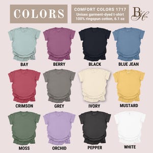 May include: A display of Comfort Colors 1717 unisex garment-dyed t-shirts in various colors. The shirts are 100% ringspun cotton, 6.1 oz. Colors include Bay, Berry, Black, Blue Jean, Crimson, Grey, Ivory, Mustard, Moss, Orchid, Pepper, and White.