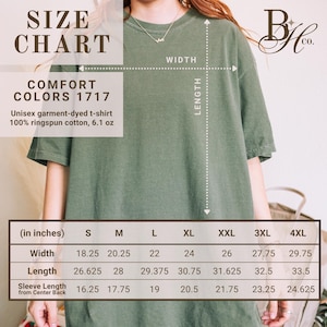 May include: A size chart for a unisex garment-dyed t-shirt in olive green. The chart displays measurements in inches for width, length, and sleeve length from the center back, ranging from size S to 4XL. The shirt is made of 100% ringspun cotton and weighs 6.1 oz.