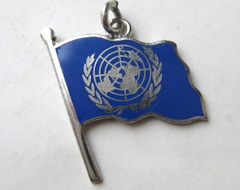 Dije vintage de los años 60 con la bandera de las Naciones Unidas en plata de ley y esmalte azul.
