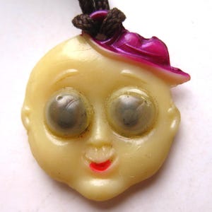 Pulseira vintage dos anos 20 e 30 com celulóide Cracker Jack, olho esbugalhado, rosto, cabeça, sorte, berloque, prêmio