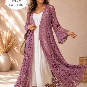May include: A long, open-front, mauve crochet cardigan with bell sleeves and a scalloped hem. The cardigan is worn over a white dress. The image includes the text "PDF PATTERN" in a white oval.