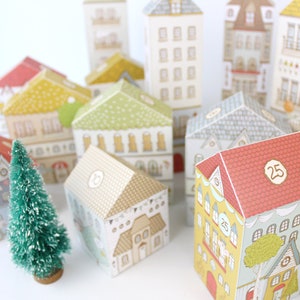 25 uniquely designed paper houses with numbers on the roofs for counting down to Christmas