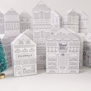 A sample of printed and assembled advent calendar Christmas houses with bottle brush trees