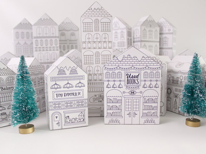 A sample of printed and assembled advent calendar Christmas houses with bottle brush trees
