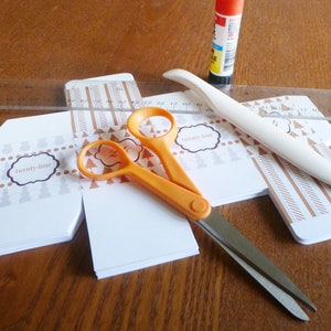 Advent calendar boxes cut out with scissors, bone folder, ruler, and glue stick