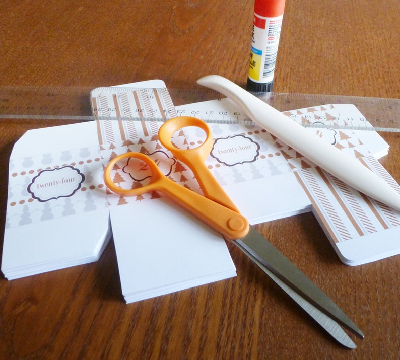 Advent calendar boxes cut out with scissors, bone folder, ruler, and glue stick