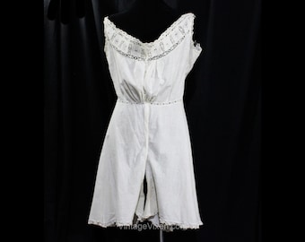 May include: White cotton undergarment with lace trim and a button closure. The garment has a split leg design and a ruffled hem.