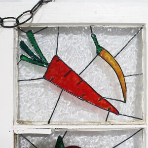 May include: A stained glass window panel featuring a red carrot and a yellow chilli pepper on a white background.