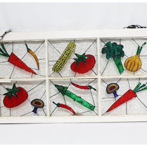 May include: A white window pane with a stained glass design featuring various vegetables, including carrots, tomatoes, onions, peppers, and mushrooms. The vegetables are painted in bright colours on the glass.