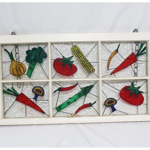 May include: A white window frame with nine panes of glass, each featuring a hand-painted vegetable design. The vegetables include carrots, onions, broccoli, tomatoes, peppers, corn, and mushrooms. The vegetables are painted in bright colours, including red, green, yellow, orange, and purple.