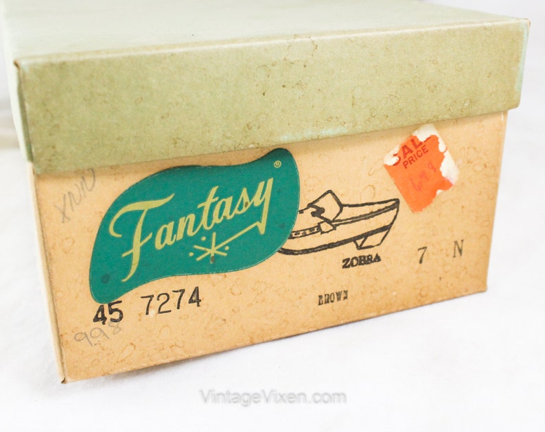 May include: A vintage shoe box with a green and gold label that says "Fantasy" and a picture of a brown shoe. The box is labeled with the numbers "45 7274" and "7 N".