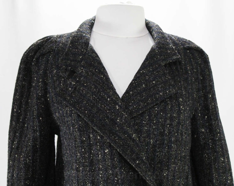 May include: A black and gold tweed blazer with a double-breasted closure and a v-neck collar.