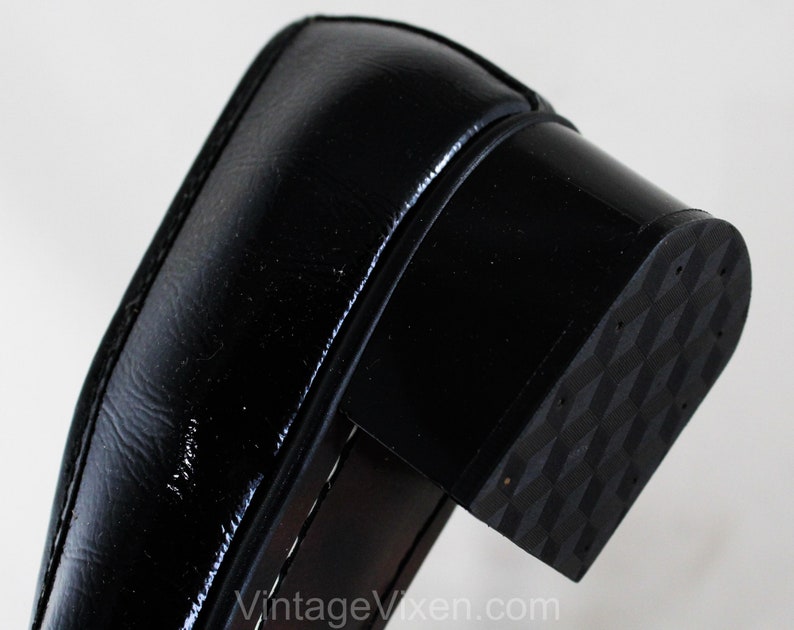 May include: Close-up of the black rubber sole of a black leather shoe. The sole has a textured pattern.